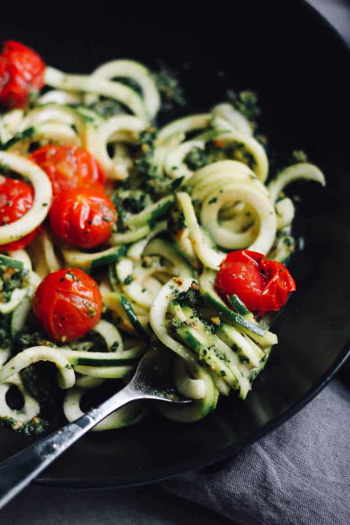 Zucchini Noodles with Kale Almond Pesto | Destination Delish - Spiralized zucchini pasta tossed with a healthy pesto of kale, almonds, garlic, olive oil, and lemon juice.
