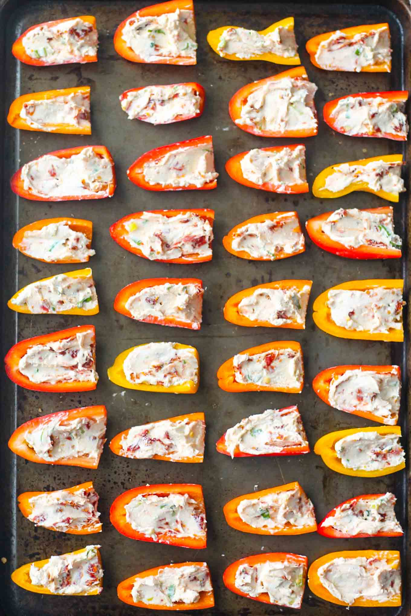 Pre-baked stuffed peppers on a sheet pan.
