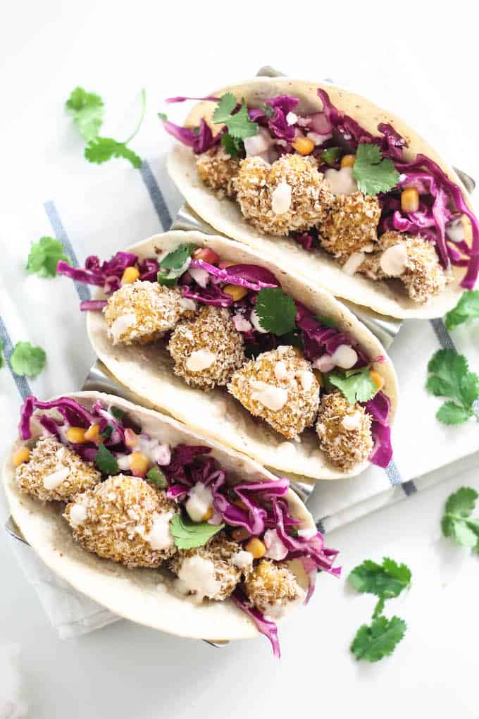 Crispy Cauliflower Tacos | Destination Delish - healthy tacos bursting with flavor and texture thanks to the crispy baked cauliflower, tangy slaw, and spicy chipotle cream