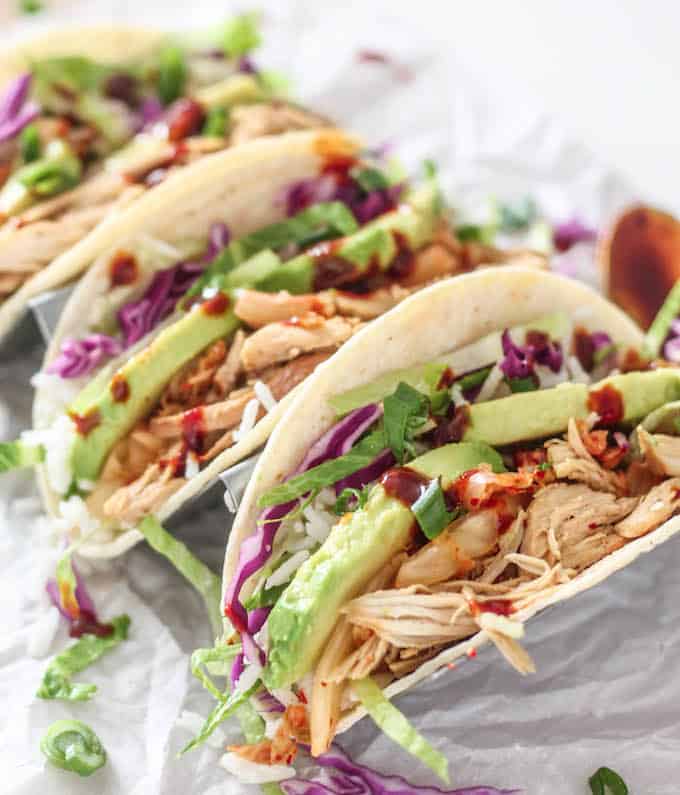 Korean Pulled Chicken Tacos | Destination Delish - Korean-inspired tacos filled with tender pulled chicken, kimchi, and lettuce. It’s a quick and healthy dinner the whole family will love!