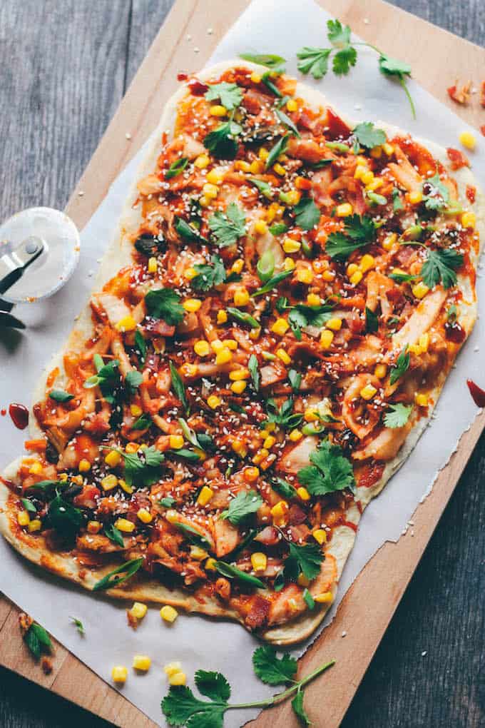 Kimchi, Bacon, and Corn Pizza | Destination Delish - A flatbread pizza bursting with flavor! Topped with kimchi, salty bacon, sweet corn, and Korean BBQ sauce, this is one unforgettable pizza.