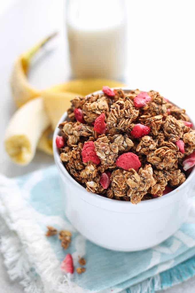 Strawberry Banana Chia Granola | Destination Delish - A nut free granola sweetened with maple syrup and strawberry banana puree. The huge, crunchy oat and chia clusters will taste divine in your morning yogurt or oatmeal! Vegan, nut free, dairy free.