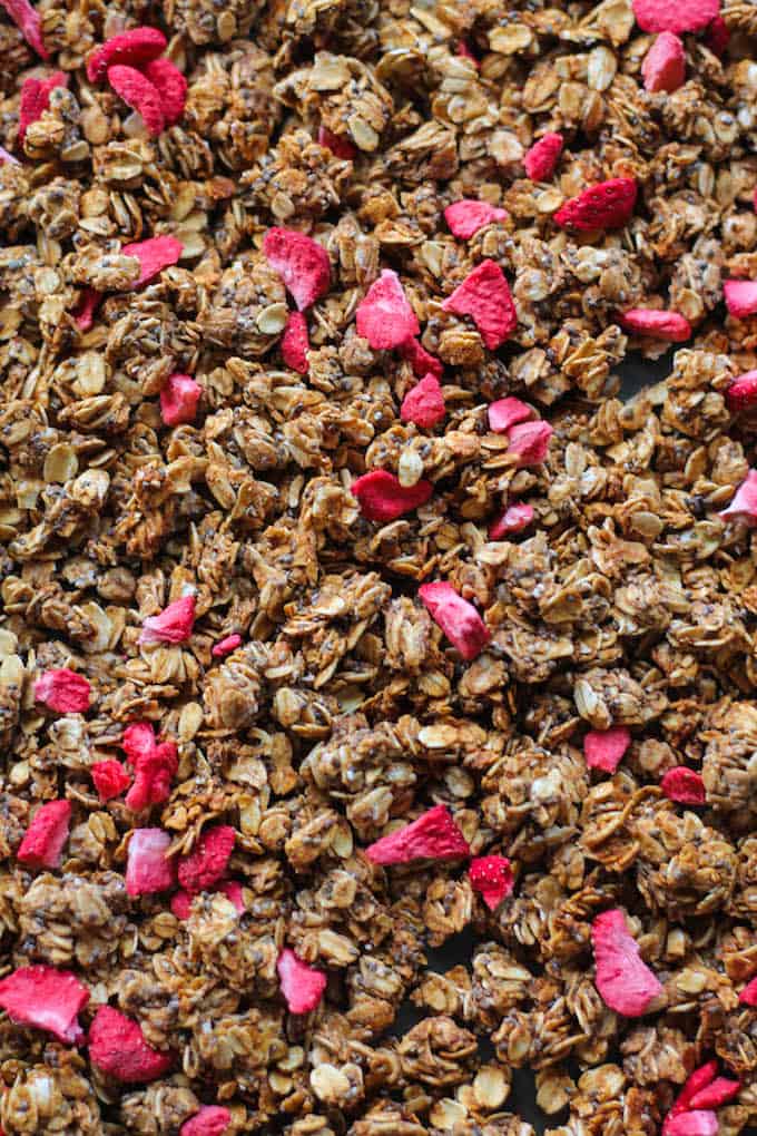 Strawberry Banana Chia Granola | Destination Delish - A nut free granola sweetened with maple syrup and strawberry banana puree. The huge, crunchy oat and chia clusters will taste divine in your morning yogurt or oatmeal! Vegan, nut free, dairy free.