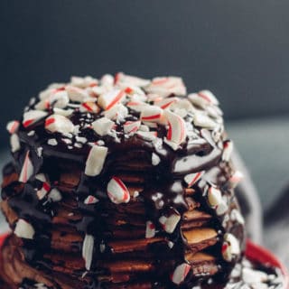 Peppermint Hot Chocolate Pancakes | Destination Delish - Chocolate chip pancakes, drenched in hot mint chocolate sauce, and topped with crushed candy canes.