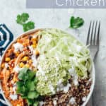 Easy salsa chicken in a bowl with quinoa and lettuce, and topped with guacamole, sour cream, and cotija cheese