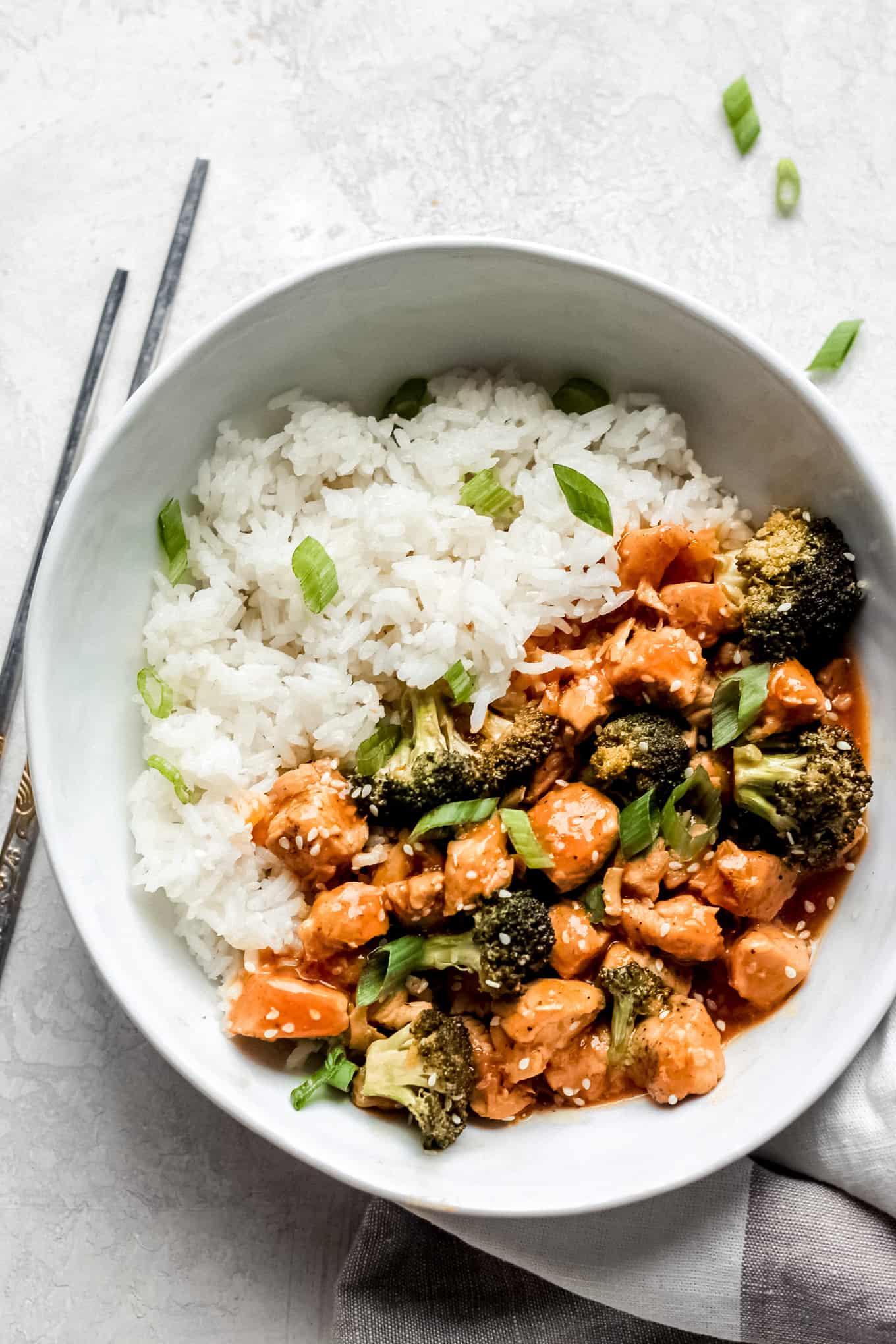 Orange chicken and broccoli in a bowl with a side of rice