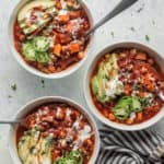 Chili in white bowls with a spoon dipped in each bowl