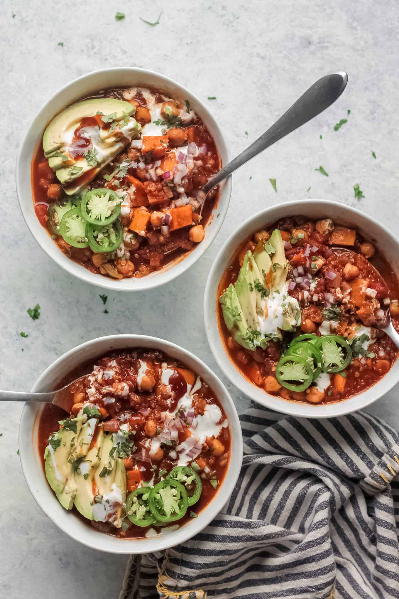 Chili in white bowls with a spoon dipped in each bowl