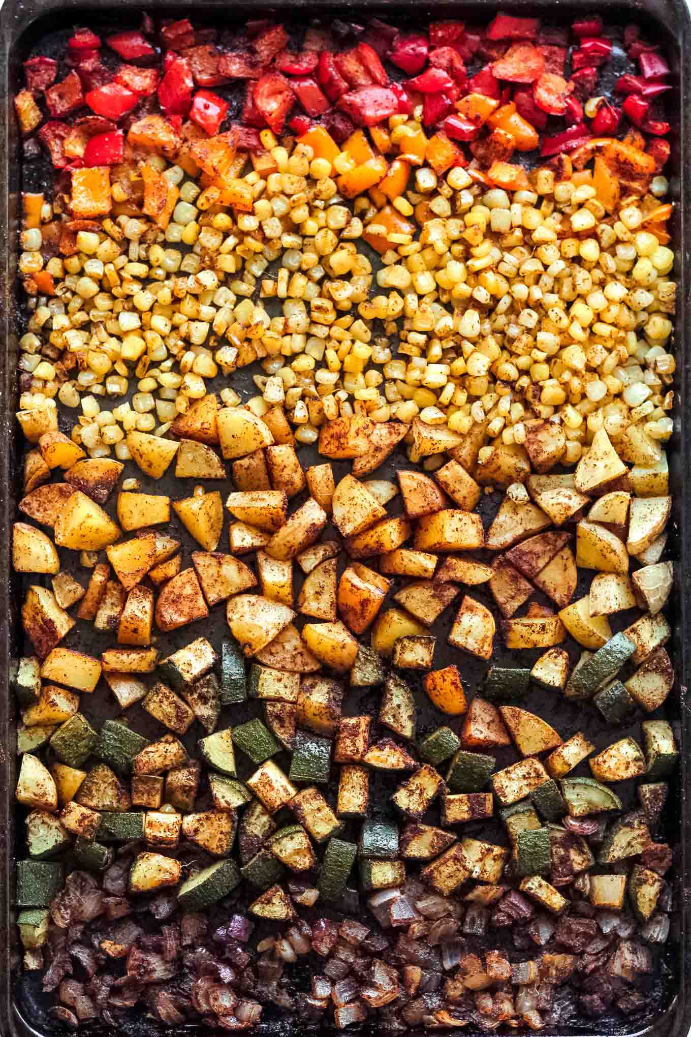 The sheet pan of peppers, zucchini, corn, and potatoes after roasting