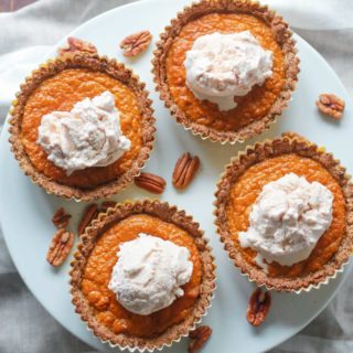 Four mini pumpkin pies on a cake stand