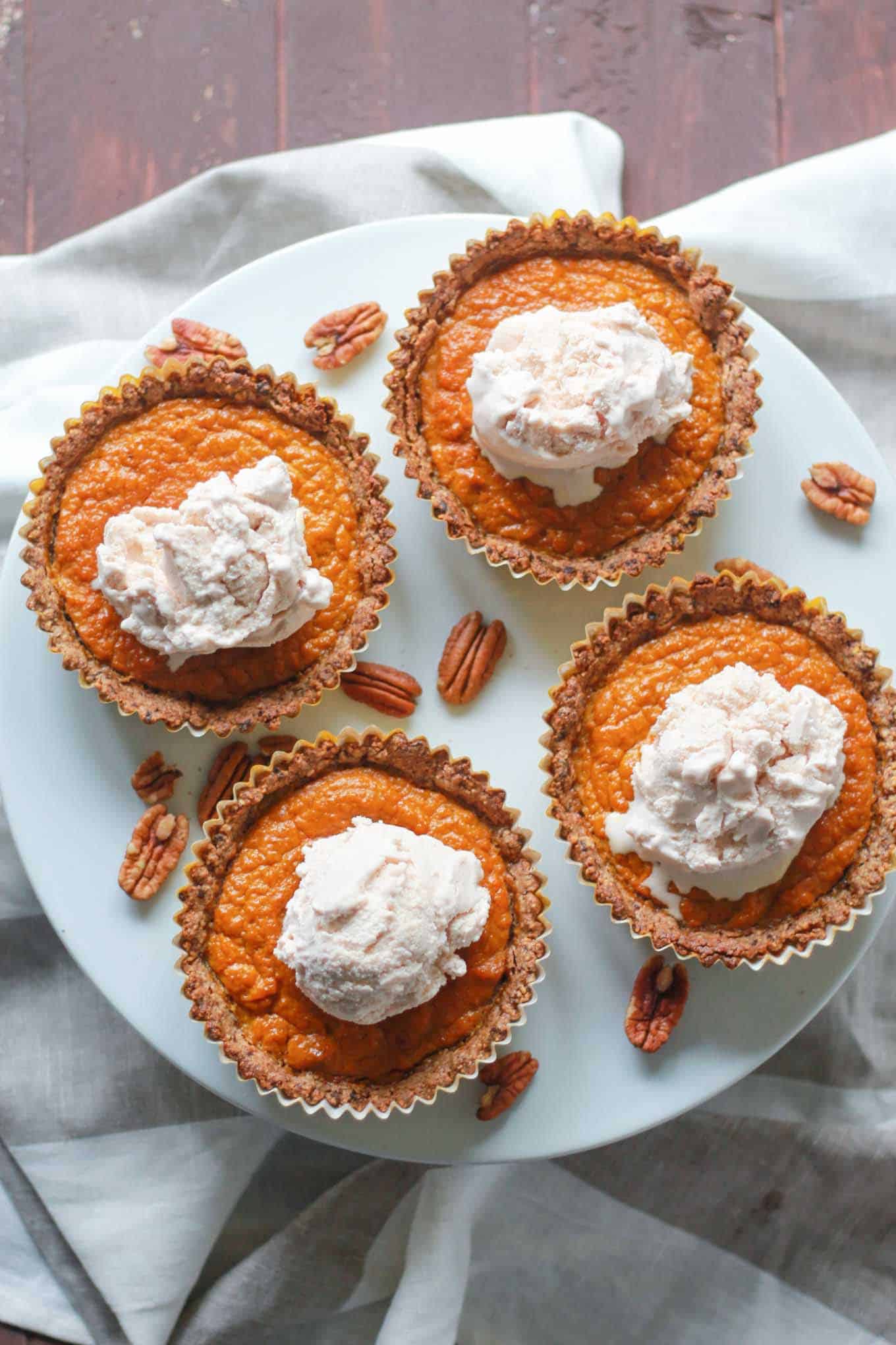 Four mini pumpkin pies on a cake stand